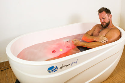 Athlete performing a cold immersion recovery session in a 1600mm Dreampod fiberglass ice bath to reduce inflammation and boost dopamine