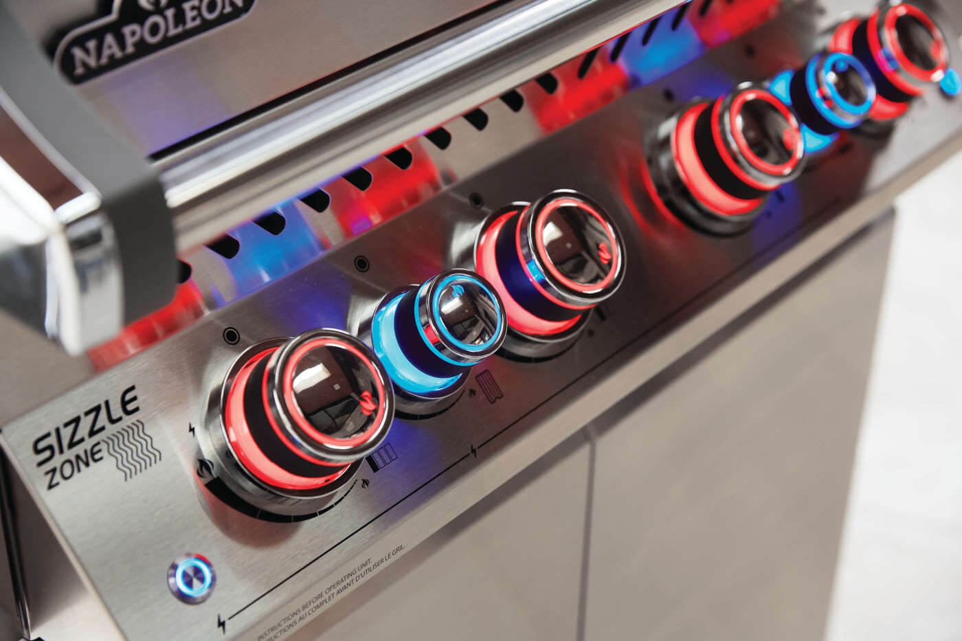 built-in gas grill with illuminated control knobs at night
