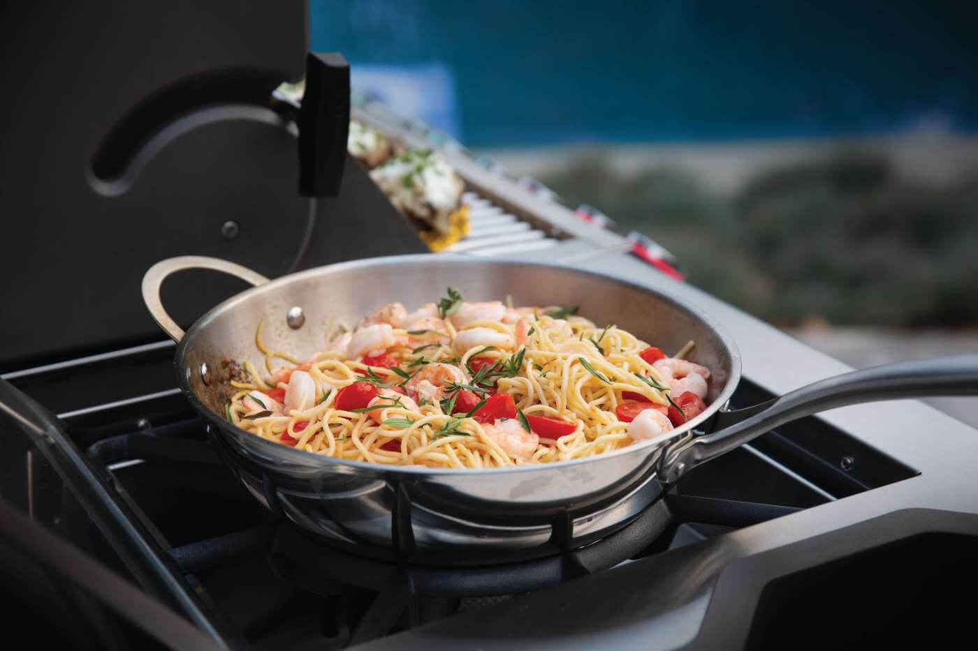 high-performance outdoor grill with side burner in use