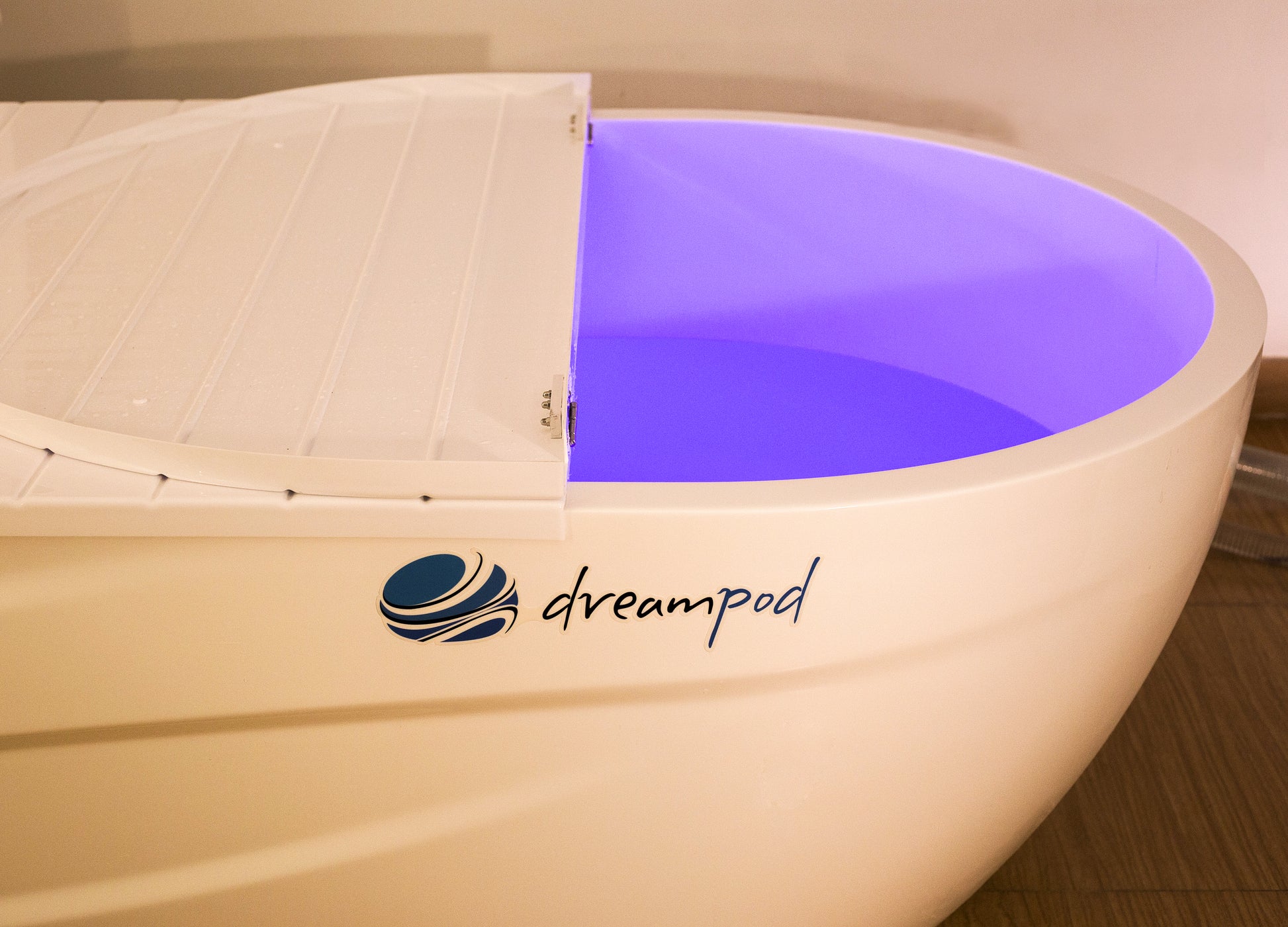 Interior of a sensory deprivation tank featuring blue LED mood lighting and anti-slip flooring.